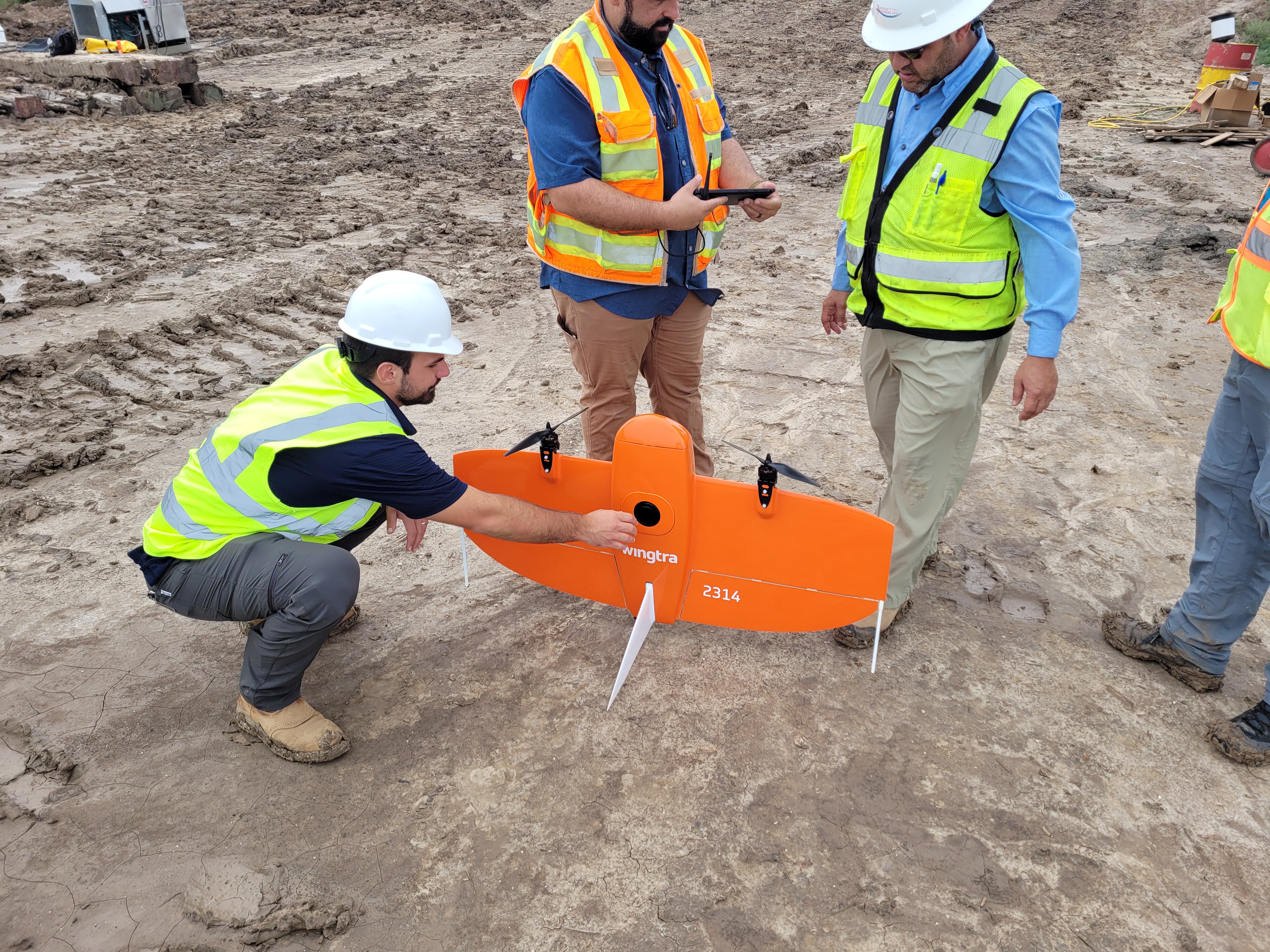 Survey field crew preparing a fixed-wing UAS for site capture